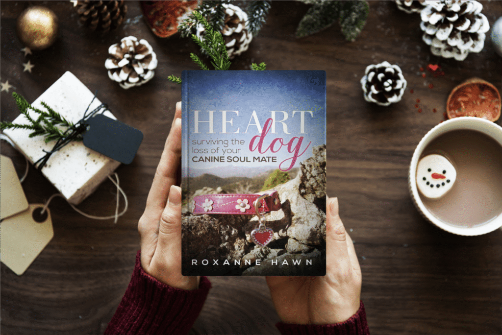 Heart Dog Surviving the Loss of Your Canine Soul Mate by Roxanne Hawn

Books by Roxanne Hawn

Book in a white woman's hands with pine cones, a gift box, and a cup of hot chocolate with a marshmallow that looks like a snowman's face